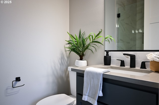 bathroom featuring an enclosed shower, vanity, and toilet