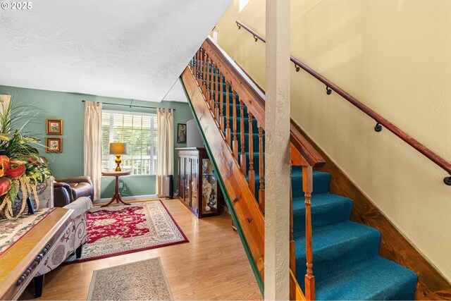 1042 W State Route 4, Cathlamet, WA 98612 - stairway with a textured ceiling, a textured wall, baseboards, and wood finished floors