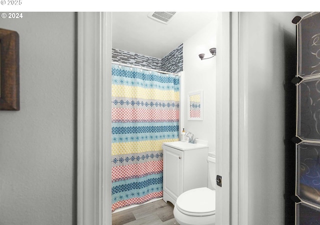 bathroom with hardwood / wood-style floors, vanity, curtained shower, and toilet