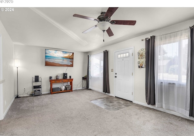 foyer entrance featuring carpet, vaulted ceiling, and ceiling fan