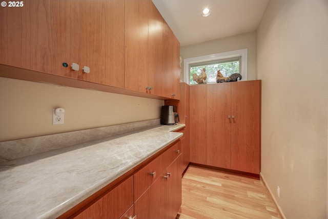 kitchen with light wood finished floors, light countertops, and baseboards