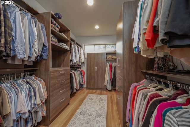 walk in closet with light wood-style floors