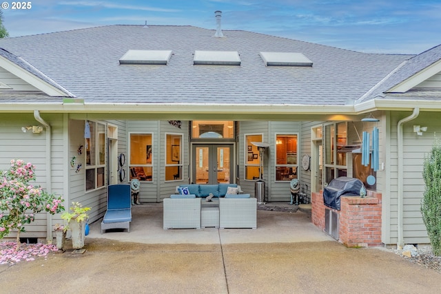 exterior space with french doors, a shingled roof, and a patio area