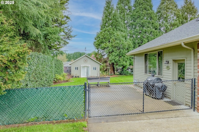 view of patio featuring an outdoor structure, fence, and a gate