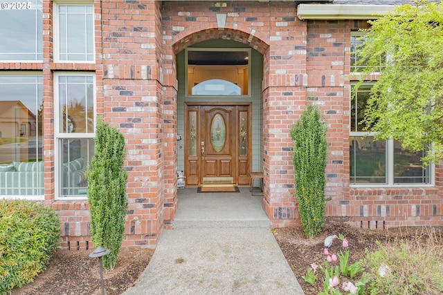 entrance to property featuring brick siding