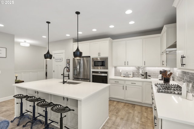 16290 SE Eckert Ln, Damascus, OR 97089 - kitchen with appliances with stainless steel finishes, light wood-style floors, white cabinets, recessed lighting, and a wainscoted wall