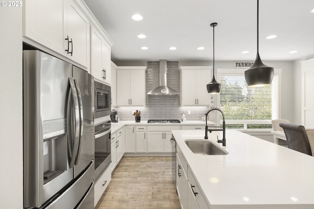 16290 SE Eckert Ln, Damascus, OR 97089 - kitchen with appliances with stainless steel finishes, wall chimney range hood, a center island with sink, recessed lighting, and light countertops