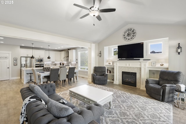 16290 SE Eckert Ln, Damascus, OR 97089 - living room with a ceiling fan, vaulted ceiling, light wood-type flooring, a glass covered fireplace, and recessed lighting