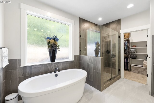 16290 SE Eckert Ln, Damascus, OR 97089 - bathroom featuring a walk in closet, a shower stall, a freestanding bath, tile walls, and plenty of natural light