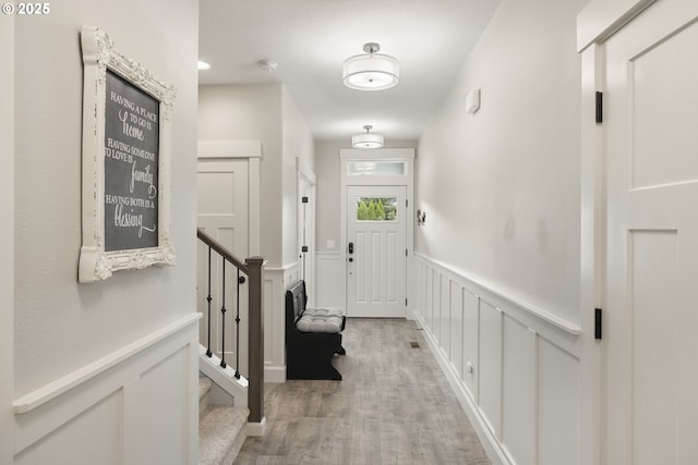 16290 SE Eckert Ln, Damascus, OR 97089 - foyer entrance with light wood-style flooring, a wainscoted wall, and stairway