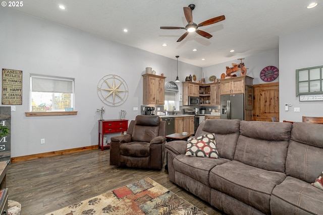 living room featuring sink, dark wood-type flooring, and ceiling fan