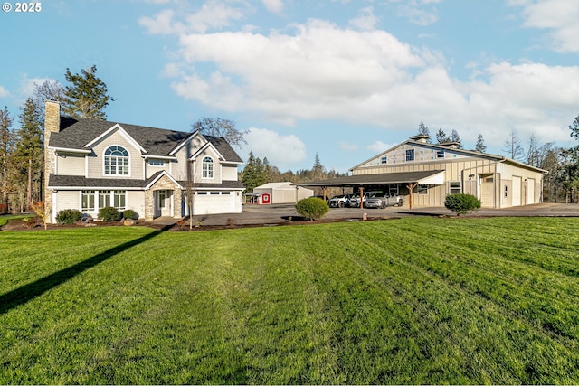 view of yard with a carport, a garage, and an outdoor structure