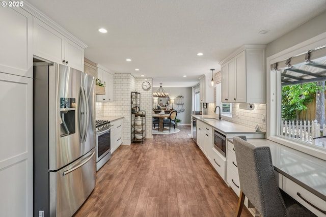 16318 SW Wright St, Beaverton, OR 97007 - kitchen with stainless steel appliances, white cabinetry, decorative backsplash, plenty of natural light, and recessed lighting