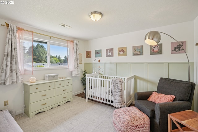 16318 SW Wright St, Beaverton, OR 97007 - bedroom featuring wainscoting, light colored carpet, and a nursery area