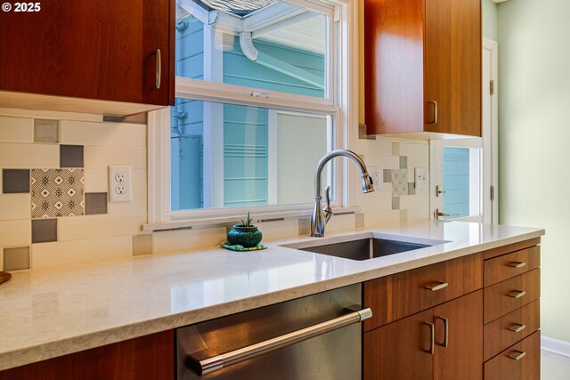 2445 SE 76th Ave, Portland, OR 97206 - kitchen with dishwasher, a sink, brown cabinetry, tasteful backsplash, and light stone counters