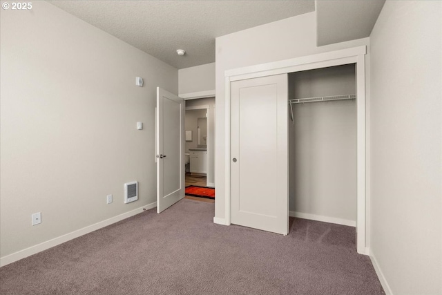 unfurnished bedroom with carpet, baseboards, and a closet