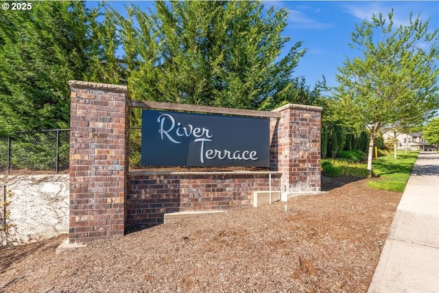 community / neighborhood sign featuring fence