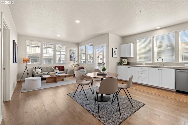 dining space featuring a textured ceiling, healthy amount of natural light, light wood-style flooring, baseboards, and recessed lighting