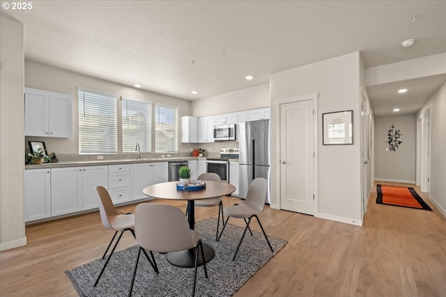 17149 SW Snowdale St Unit 203, Beaverton, OR 97007 - dining room with light wood-type flooring, baseboards, recessed lighting, and a textured ceiling