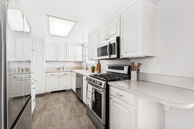 kitchen with kitchen peninsula, stainless steel appliances, white cabinetry, and sink