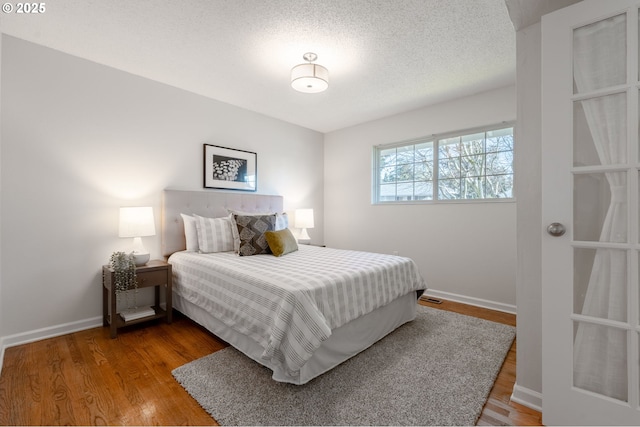 bedroom featuring wood-type flooring and a textured ceiling