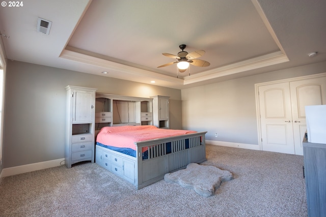 bedroom featuring a raised ceiling, carpet floors, and ceiling fan