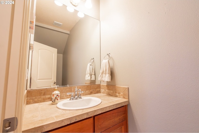 bathroom with tasteful backsplash and vanity