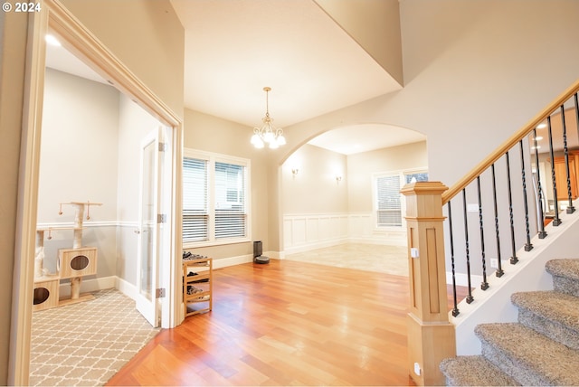 entryway with wood-type flooring and a chandelier