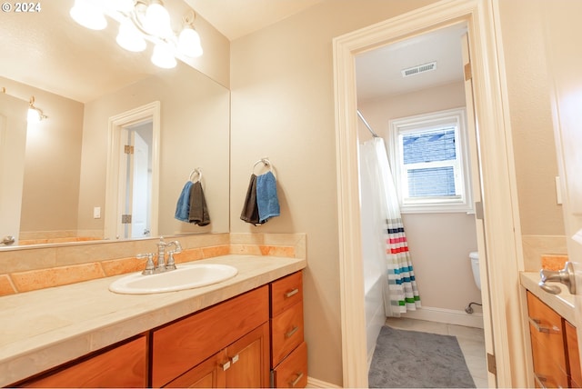 full bathroom with a chandelier, tile patterned flooring, vanity, shower / tub combo, and toilet