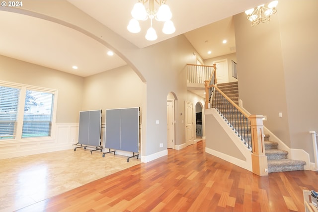 interior space featuring a high ceiling, hardwood / wood-style floors, and a notable chandelier