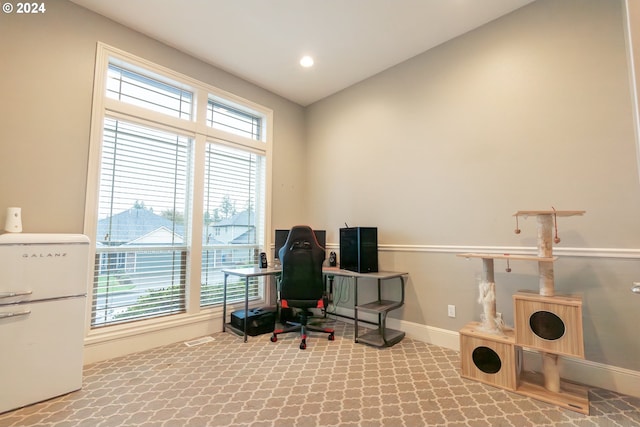 office area with lofted ceiling and carpet flooring