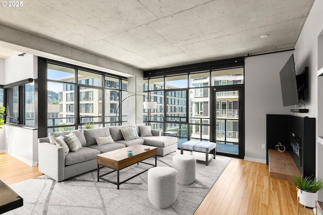 1830 NW Riverscape St Unit 406, Portland, OR 97209 - living area with plenty of natural light, baseboards, floor to ceiling windows, and wood finished floors