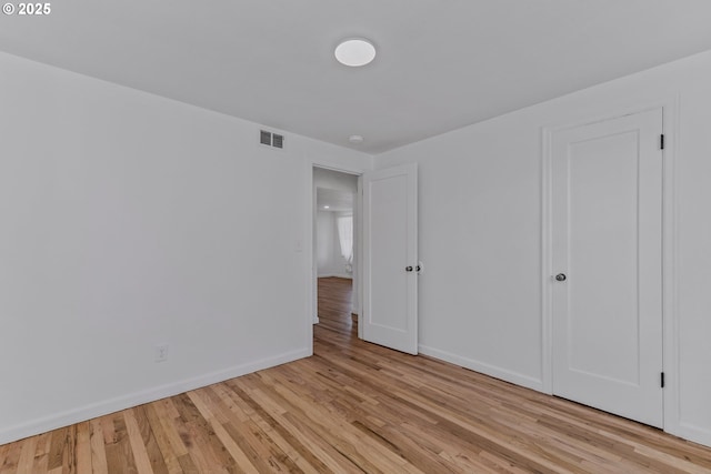 unfurnished bedroom featuring visible vents, light wood-style flooring, and baseboards