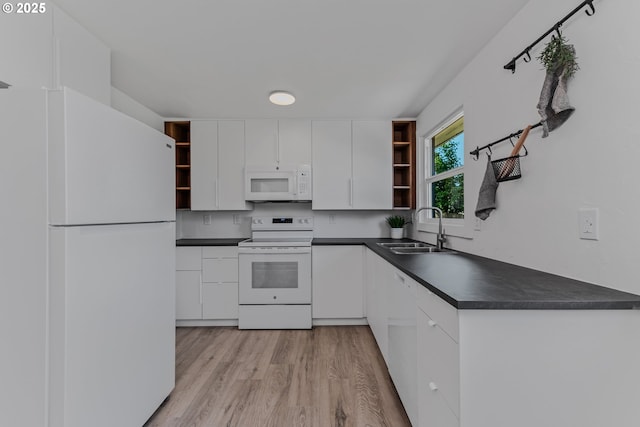 kitchen with open shelves, dark countertops, a sink, and white appliances