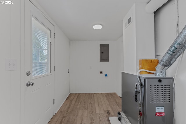 washroom featuring electric panel, laundry area, light wood finished floors, and visible vents