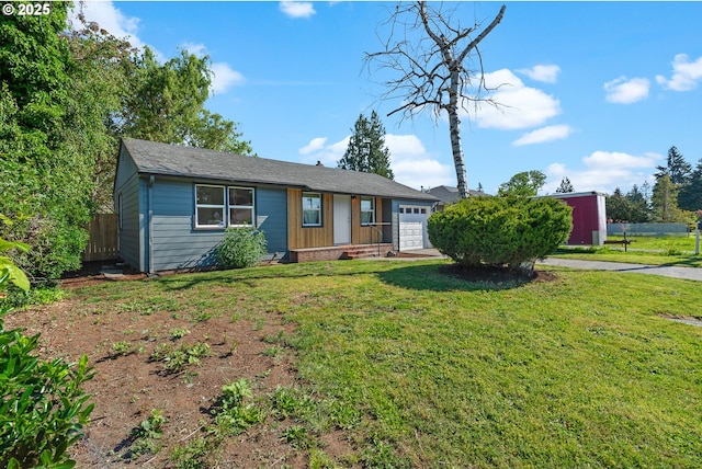 ranch-style home featuring fence, an attached garage, and a front yard