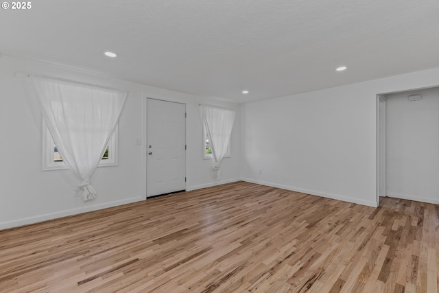 interior space with light wood finished floors, baseboards, and recessed lighting