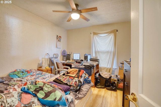 bedroom featuring wood-type flooring, ceiling fan, and a textured ceiling