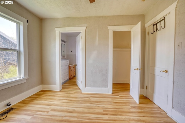 1206 E 9th St, The Dalles, OR 97058 - unfurnished bedroom with baseboards, visible vents, light wood-type flooring, and connected bathroom