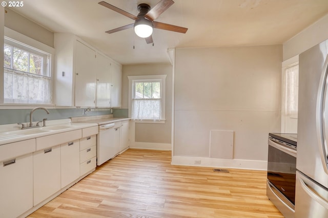 1206 E 9th St, The Dalles, OR 97058 - kitchen featuring baseboards, a sink, light wood-style flooring, and appliances with stainless steel finishes