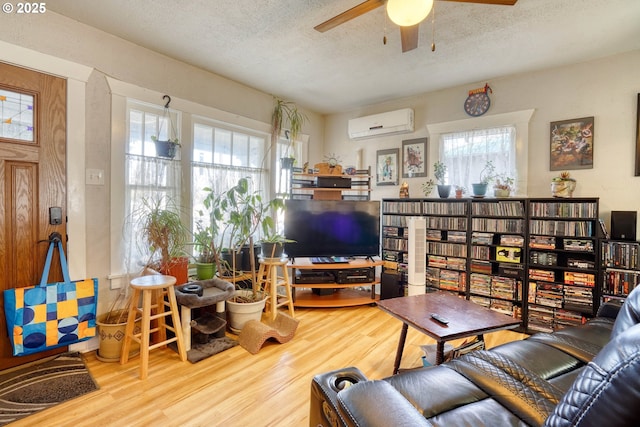 living room featuring hardwood / wood-style flooring, a textured ceiling, and a wall mounted AC