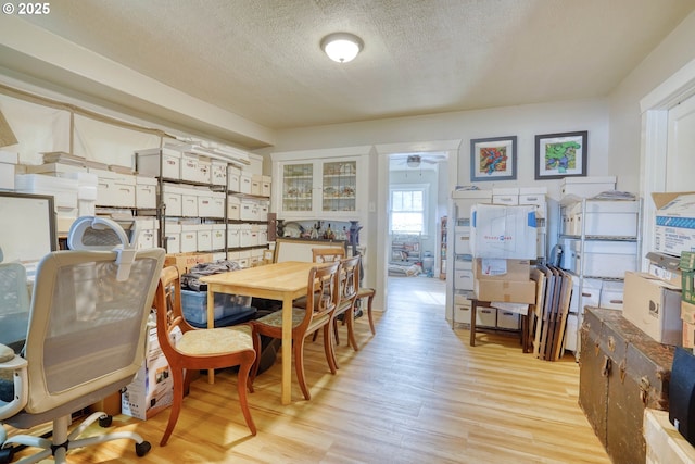 dining room featuring ceiling fan, a textured ceiling, and light wood-type flooring