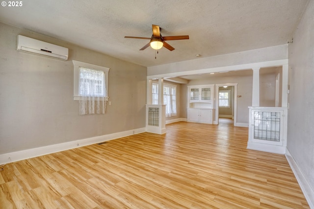 1206 E 9th St, The Dalles, OR 97058 - spare room featuring baseboards, ceiling fan, a textured ceiling, a wall mounted AC, and light wood finished floors