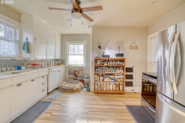 kitchen with stainless steel appliances, light wood-type flooring, and white cabinets