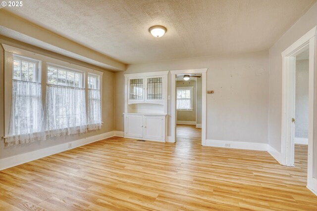 1206 E 9th St, The Dalles, OR 97058 - spare room featuring baseboards, light wood-style flooring, a textured ceiling, and ceiling fan