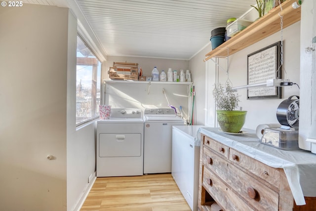 laundry area with light hardwood / wood-style floors and washer and dryer