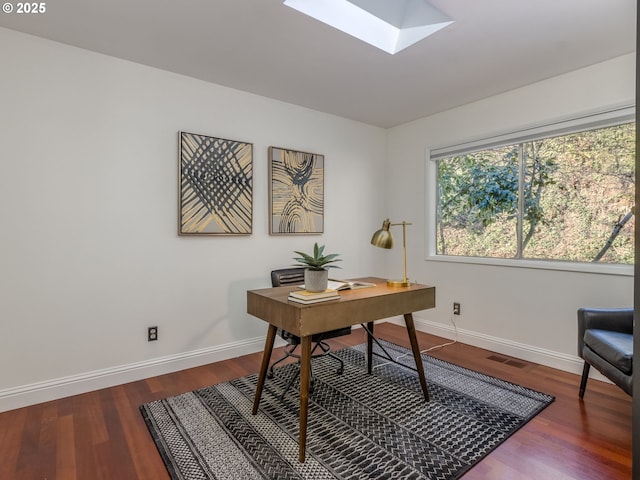 office space with hardwood / wood-style flooring and a skylight