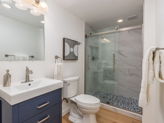 bathroom with vanity, an enclosed shower, hardwood / wood-style flooring, and toilet