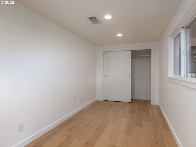 unfurnished bedroom featuring light hardwood / wood-style floors and a closet