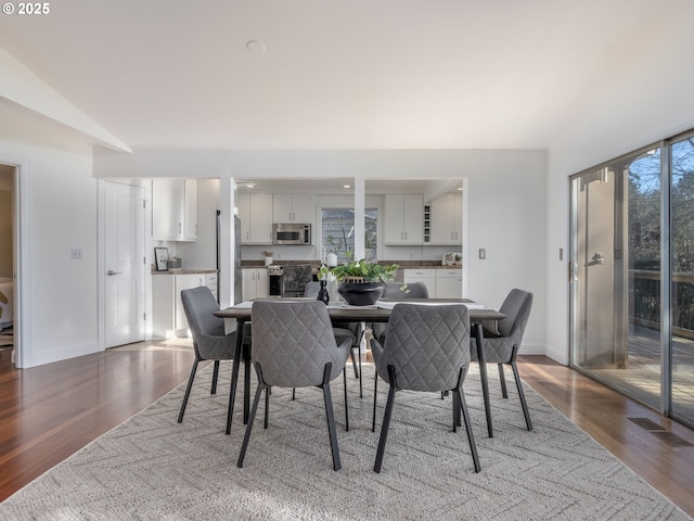 dining area with vaulted ceiling and hardwood / wood-style floors